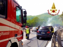 Vigili del fuoco impegnati a spegnere l'incendio del veicolo